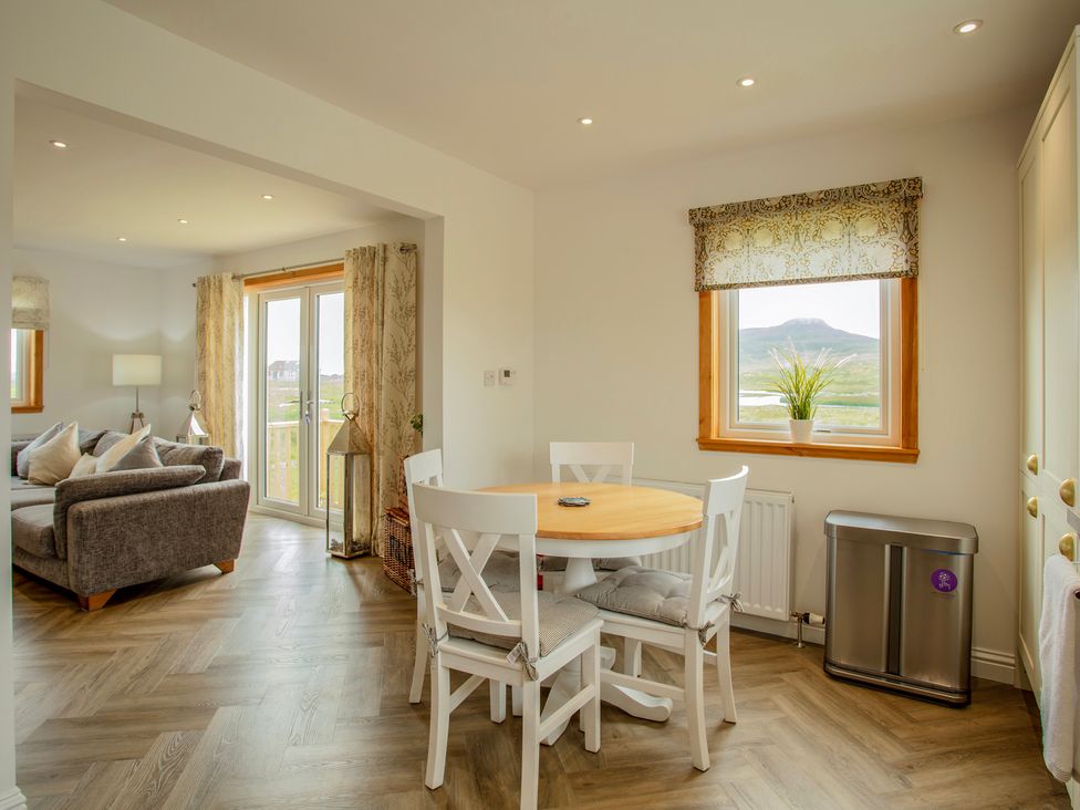 A dining area with a table and chairs at Taigh Eva near Lochmaddy