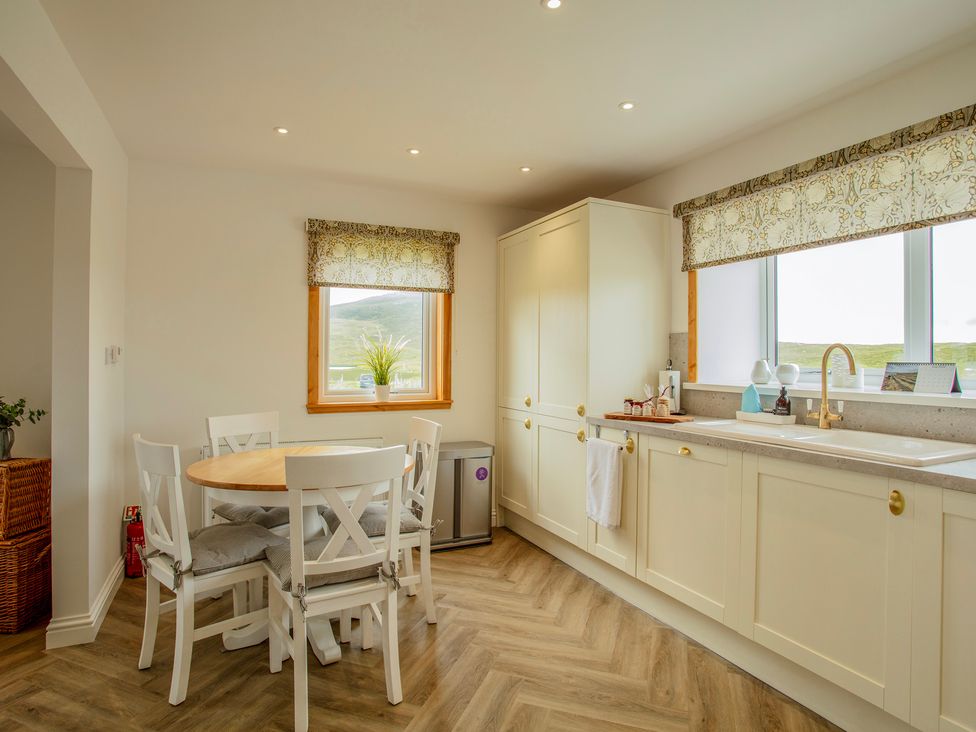 A kitchen with a table and chairs at Taigh Eva near Lochmaddy