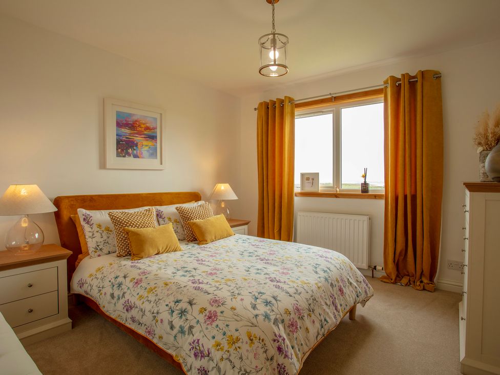 A bedroom with a bed and lamps at Taigh Eva near Lochmaddy