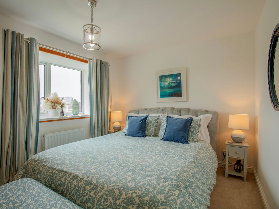 A bedroom with a bed and nightstand at Taigh Eva near Lochmaddy