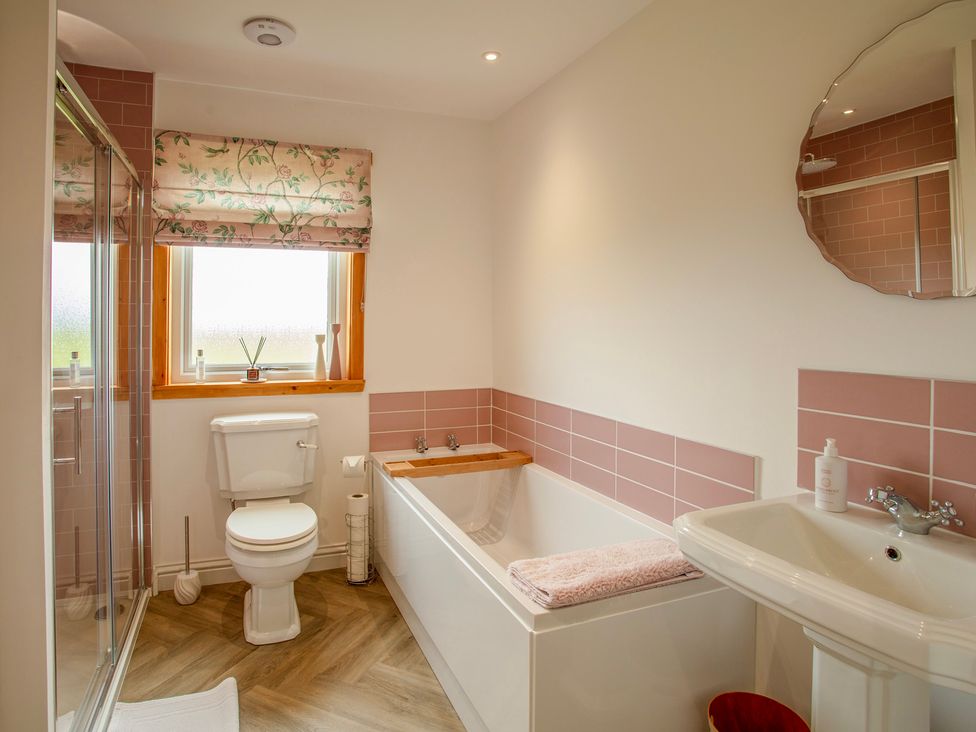 A bathroom with a bathtub, toilet, and sink at Taigh Eva near Lochmaddy