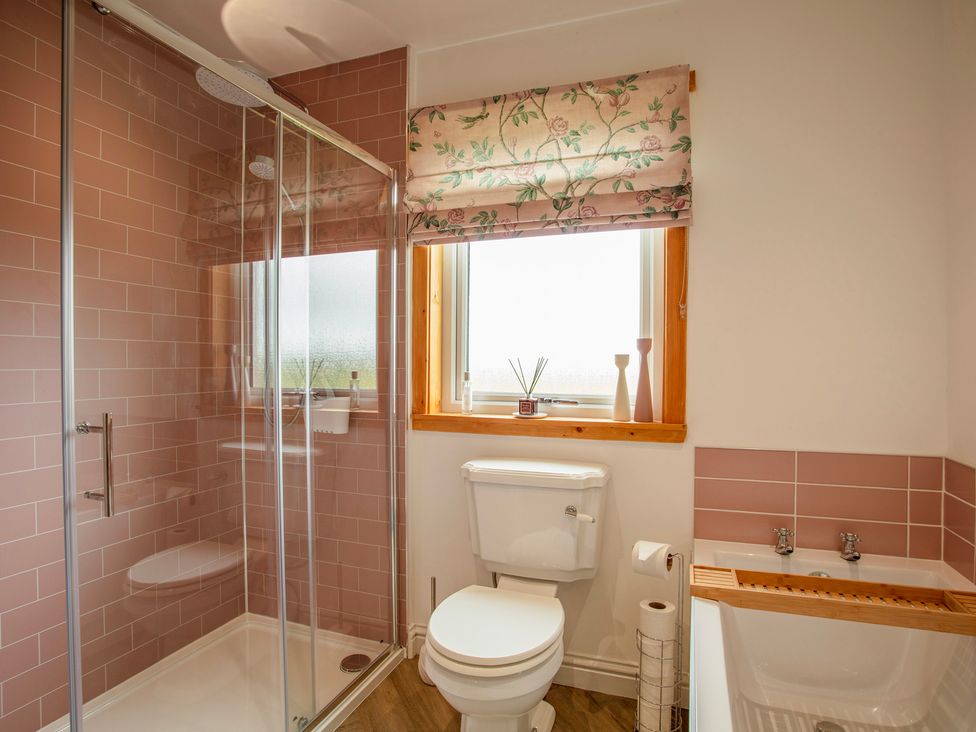 A bathroom with a shower, toilet, and sink at Taigh Eva near Lochmaddy