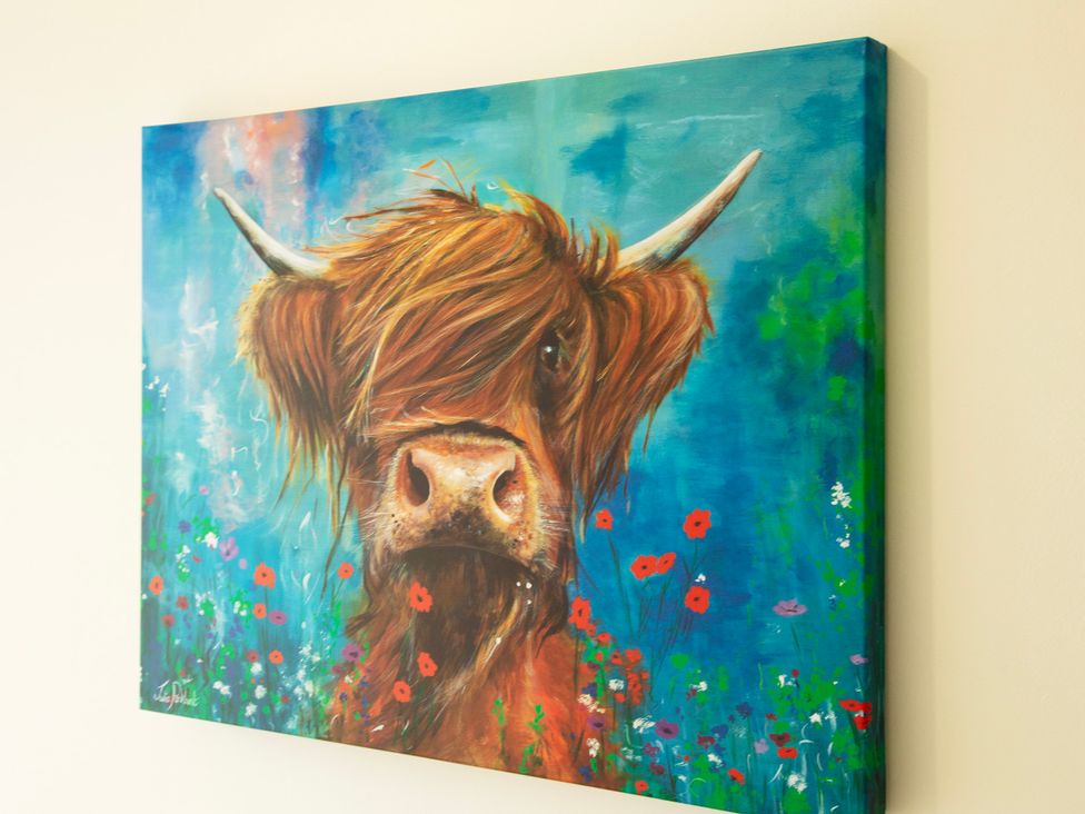 A painting of a Highland cow surrounded by flowers at Taigh Eva near Lochmaddy