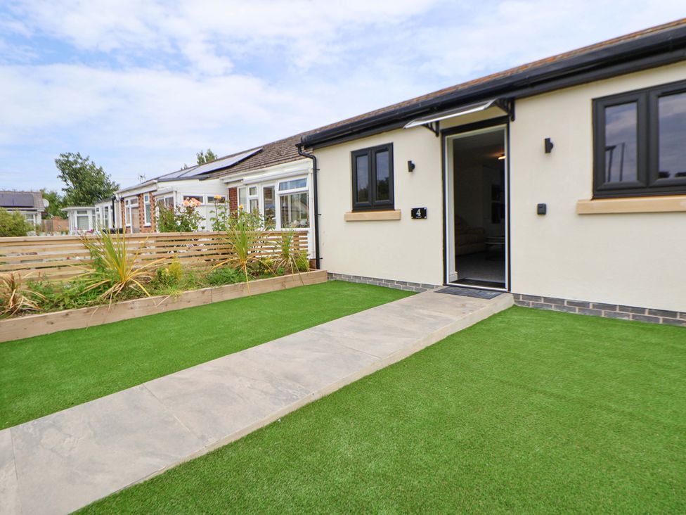 An entrance with a pathway and lawn at 4 Willow Grove - Freehold Talacre