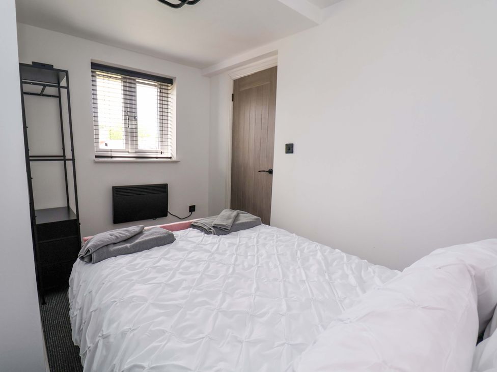 A bedroom with a bed and shelf at 4 Willow Grove - Freehold Talacre