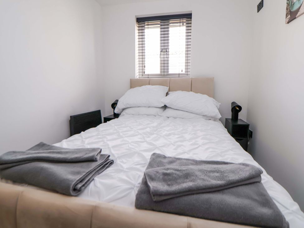 A bedroom with a bed and bedside tables at 4 Willow Grove - Freehold Talacre