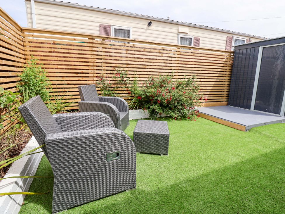 A garden with chairs and a table at 4 Willow Grove - Freehold in Talacre