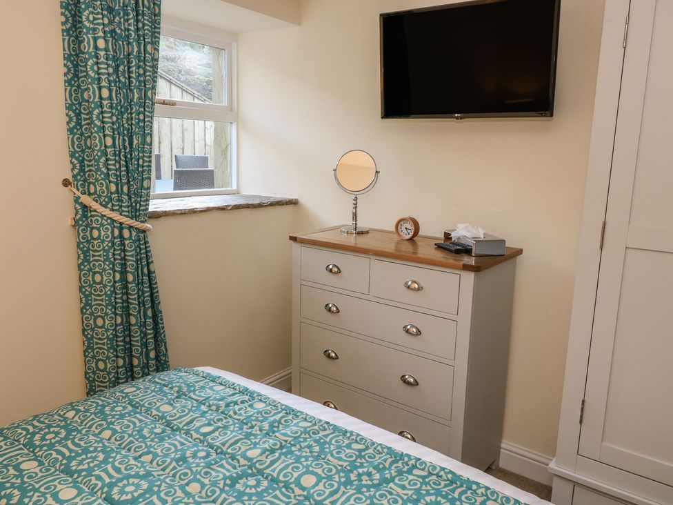 A bedroom with a dresser and television at Fogga Croft in Skipton