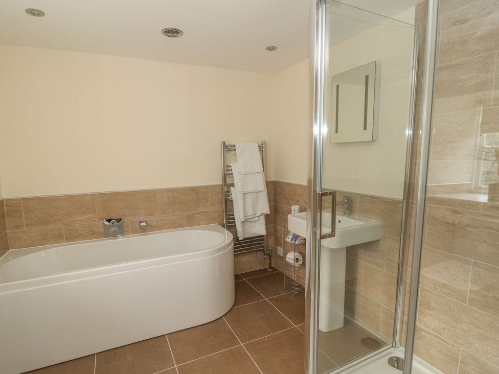 A bathroom with a bathtub, shower and sink at Fogga Croft in Skipton