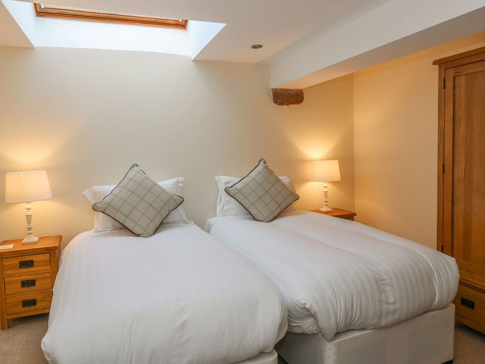 A bedroom with two beds and a lamp at Fogga Croft in Skipton