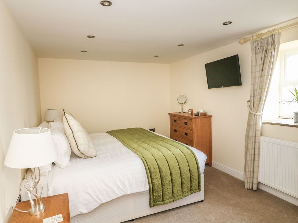 A bedroom with a bed and dresser at Fogga Croft in Skipton
