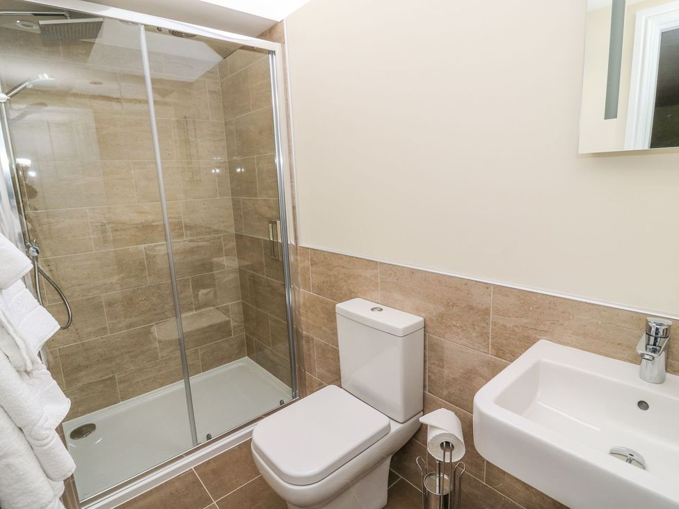 A bathroom with a shower, toilet, and sink at Fogga Croft in Skipton