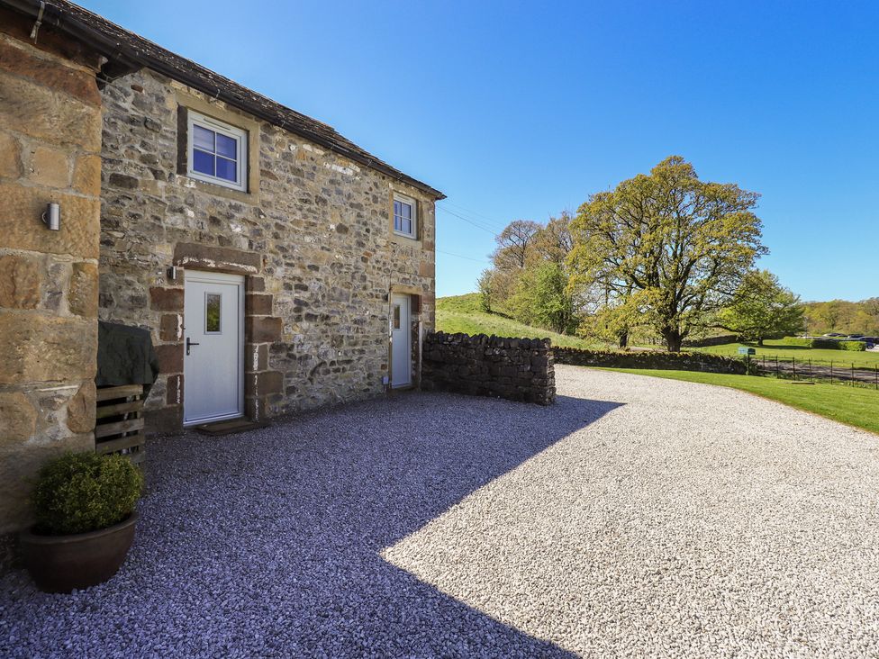 An outdoor area with a stone building and gravel driveway at Fogga Croft in Gargrave