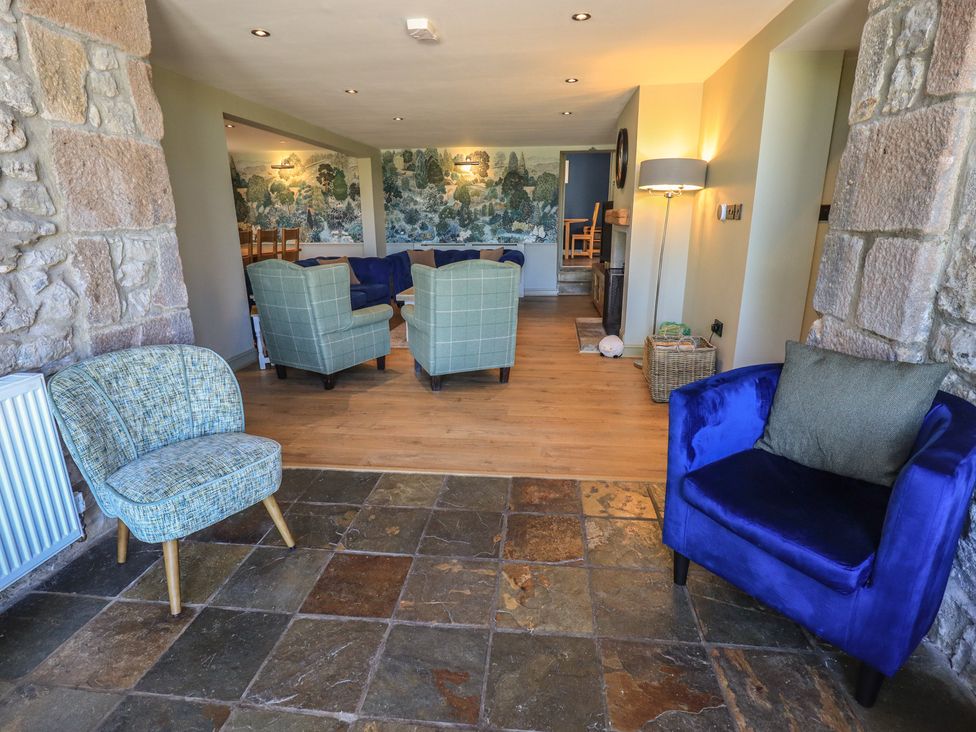 A living room with stone wall and seating at Fogga Croft in Gargrave