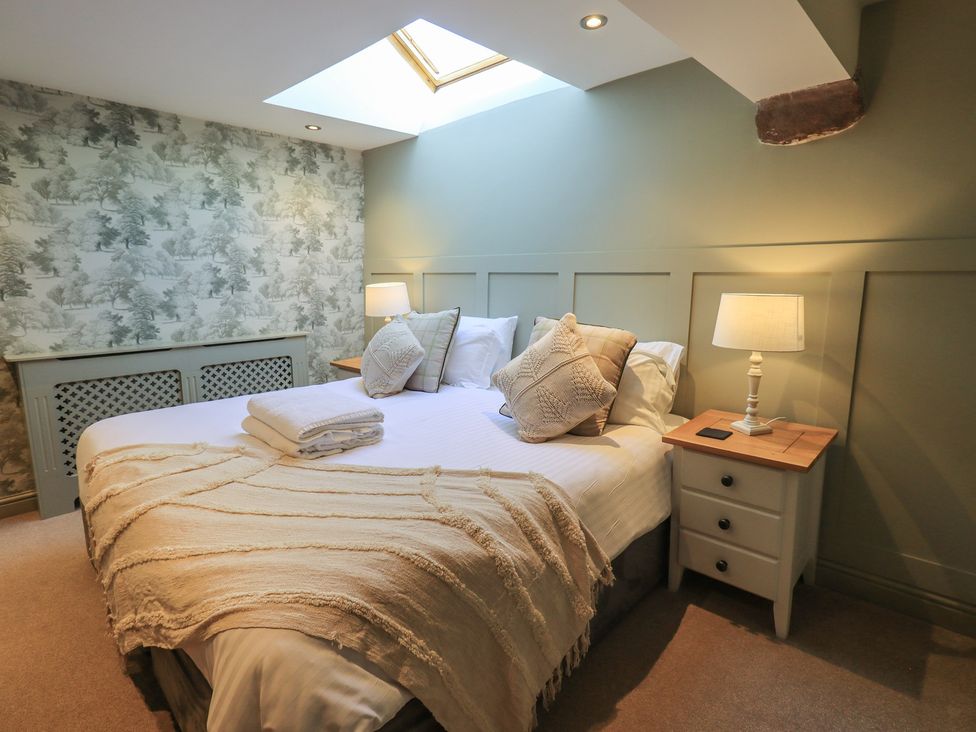 A bedroom with a bed, pillows, and a nightstand at Fogga Croft in Gargrave