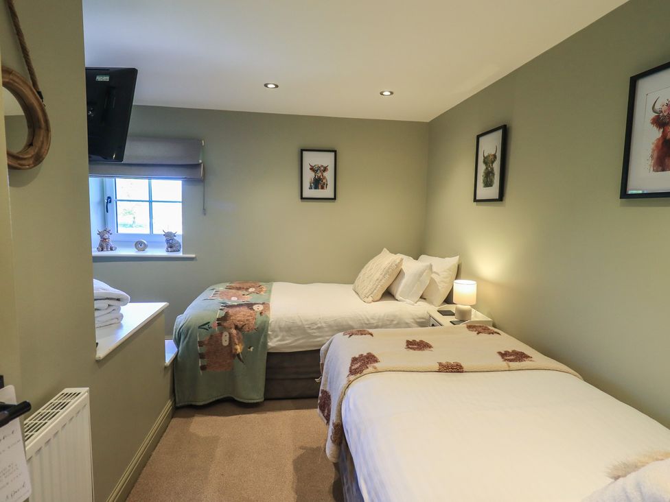 A bedroom with two beds and a tv at Fogga Croft in Gargrave