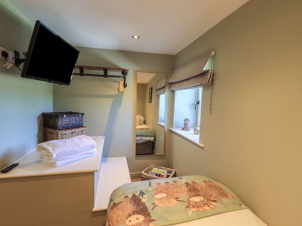 A bedroom with a television and storage basket at Fogga Croft in Gargrave