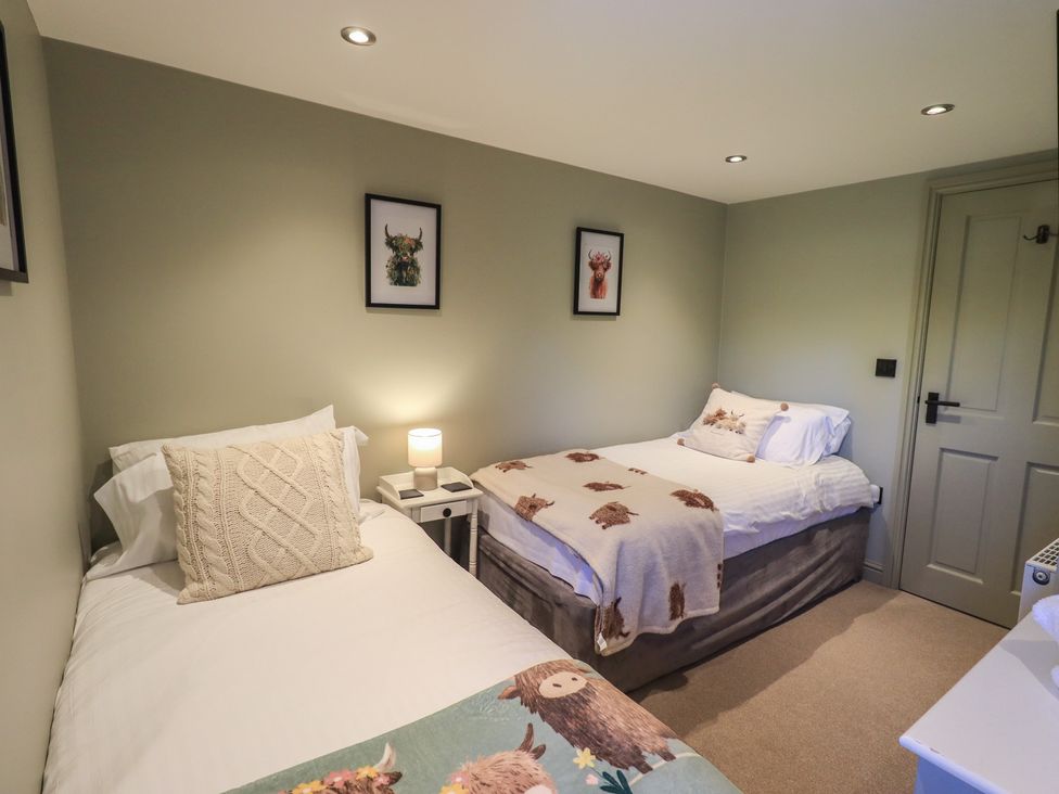 A bedroom with two beds and wall art at Fogga Croft in Gargrave
