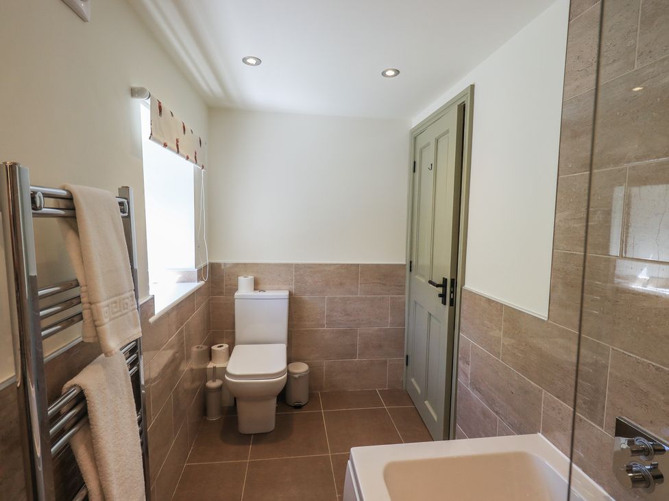 A bathroom with a toilet and bathtub at Fogga Croft in Gargrave