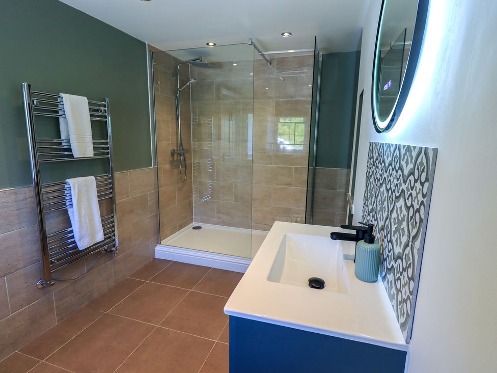 A bathroom with a shower, sink, and towels at Fogga Croft in Gargrave