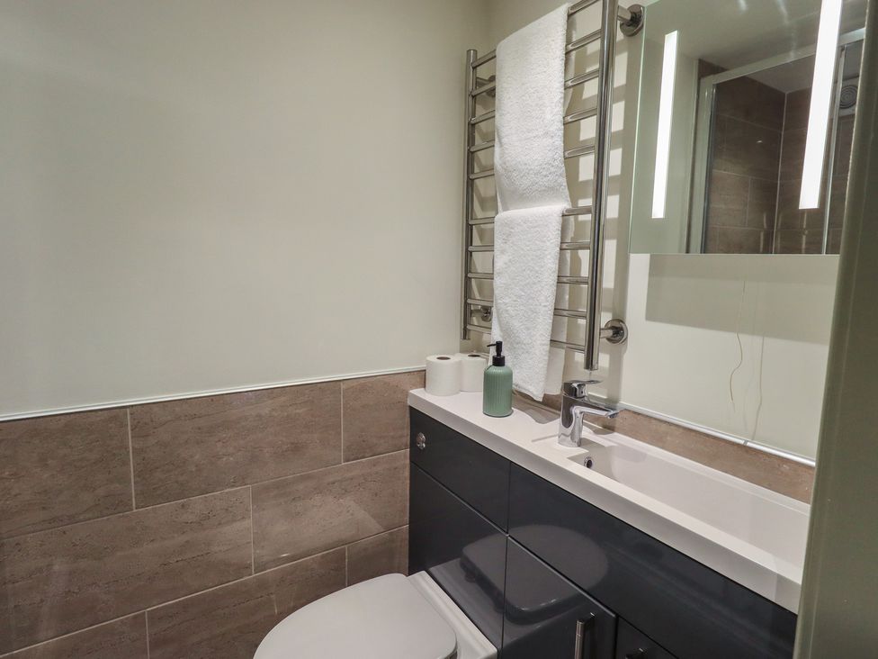 A bathroom with a toilet, sink and towel rack at Fogga Croft in Gargrave