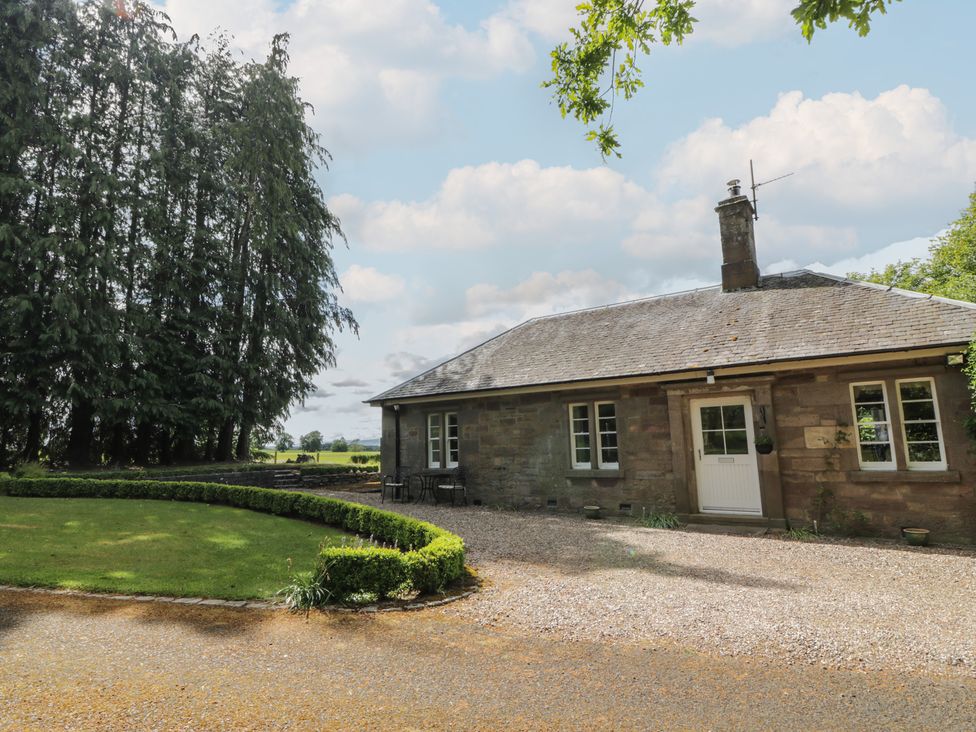A house surrounded by trees and greenery at Eagle Glen Cottage in Kettins near Coupar Angus