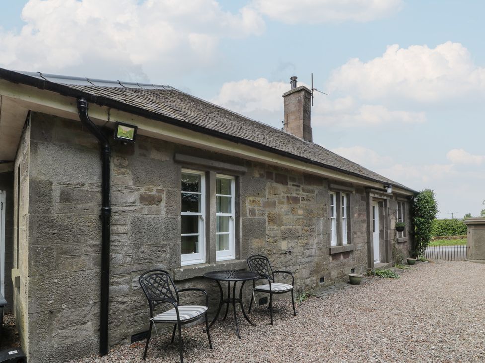 A stone exterior with a table and chairs at Eagle Glen Cottage Kettins near Coupar Angus