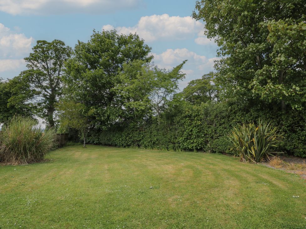 A garden with grass and trees at Eagle Glen Cottage Kettins near Coupar Angus