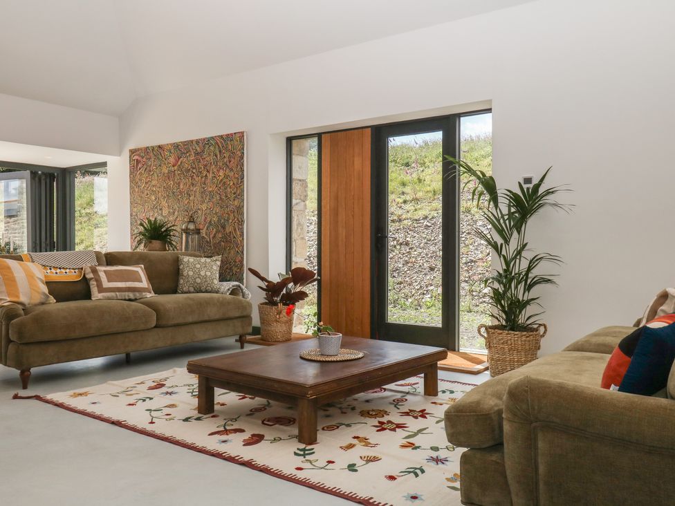 A living room with a sofa and coffee table at Reddaway Threshing Barn near Okehampton