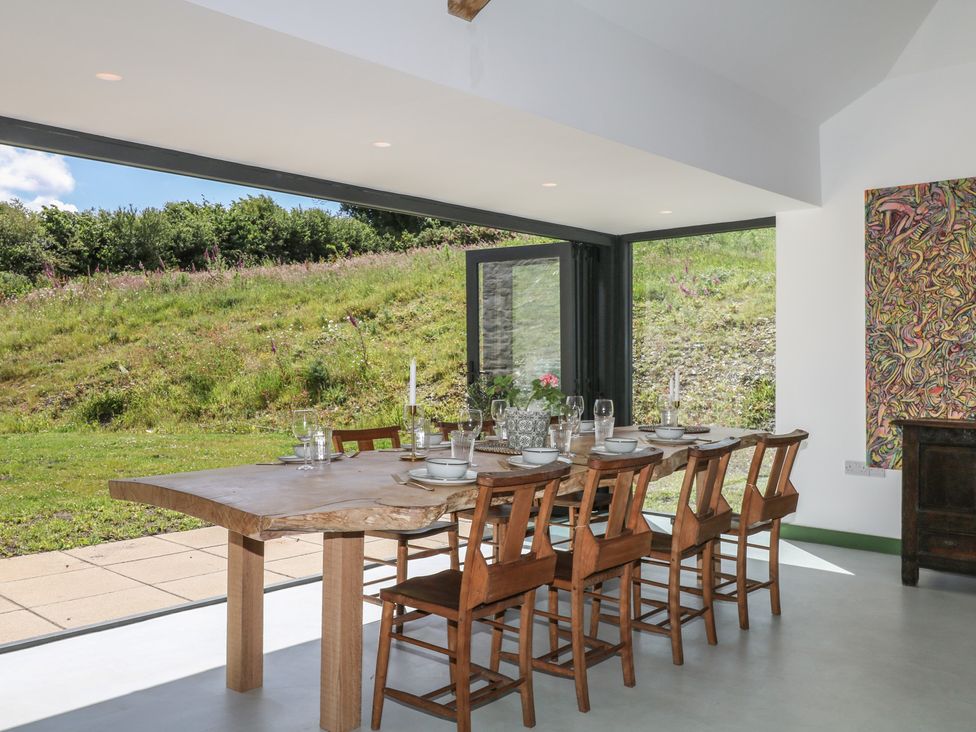 A dining room with a large table and chairs at Reddaway Threshing Barn near Okehampton