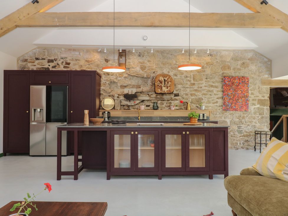 A kitchen with a modern design and stone wall at Reddaway Threshing Barn near Okehampton