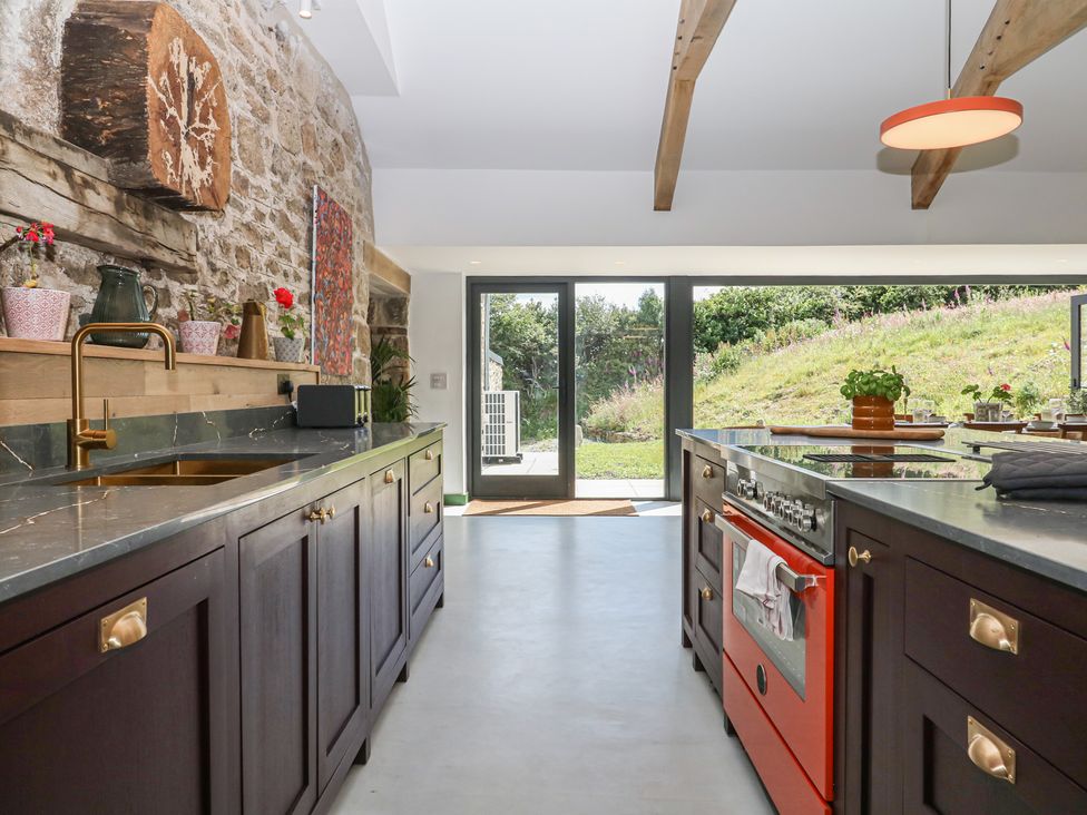A kitchen with cabinets and appliances at Reddaway Threshing Barn near Okehampton