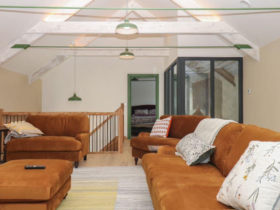 A living room with a sofa and cushions at Reddaway Threshing Barn near Okehampton