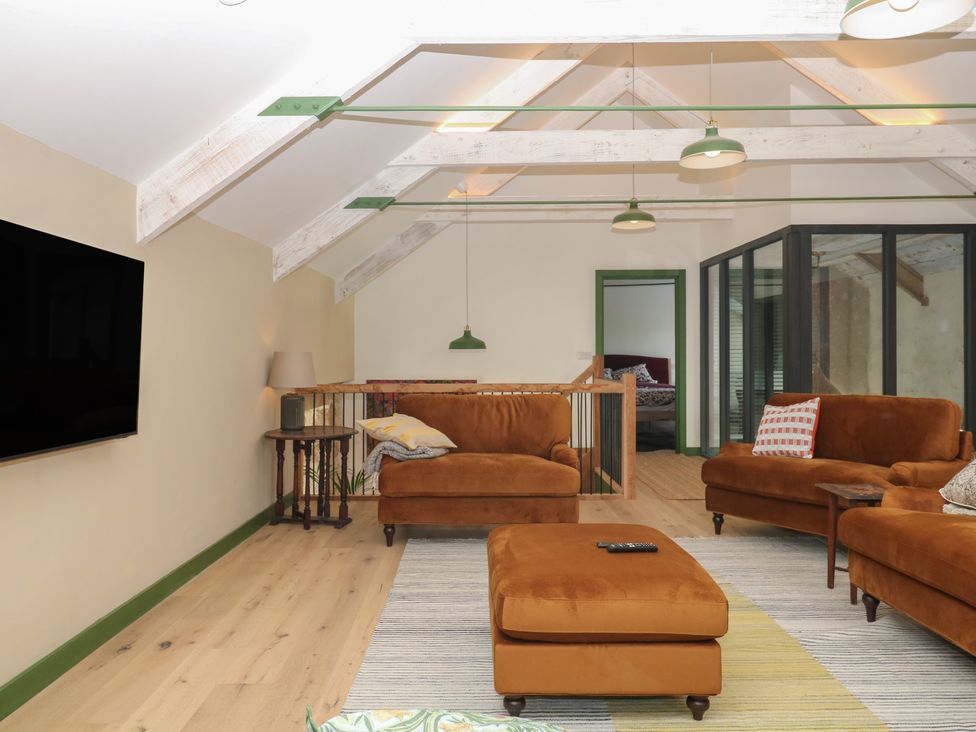 A living room with a television and sofas at Reddaway Threshing Barn near Okehampton