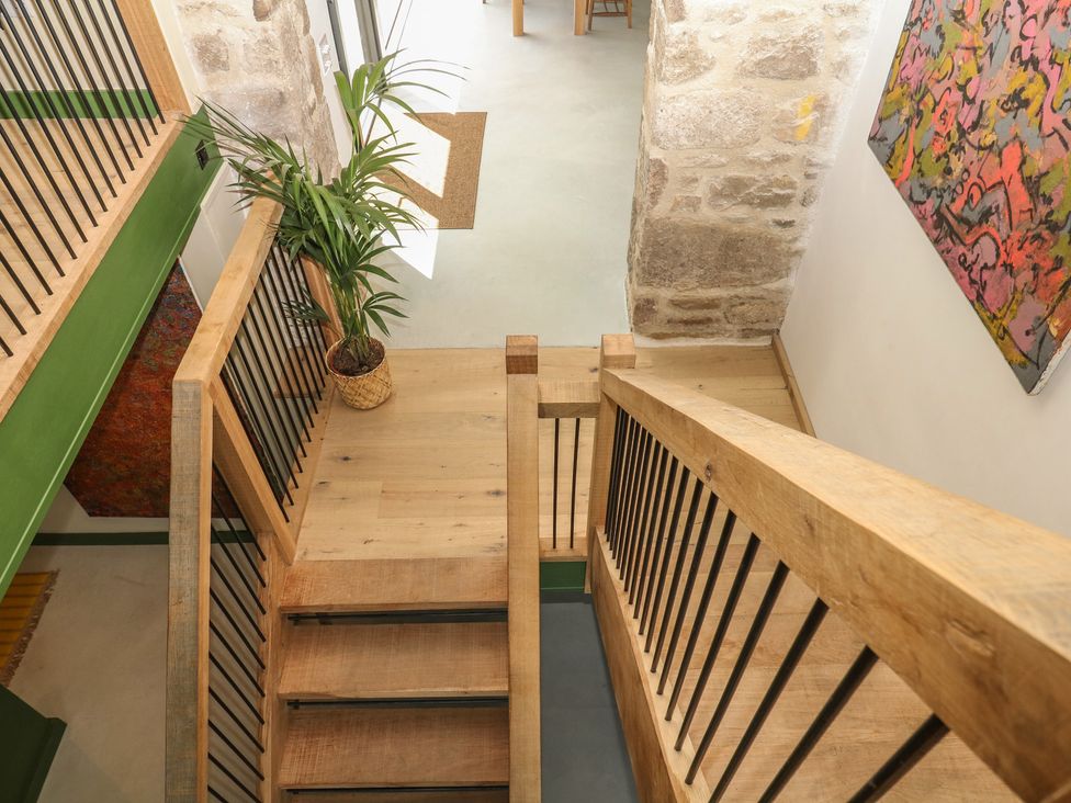 A staircase with wooden flooring and potted plant at Reddaway Threshing Barn near Okehampton