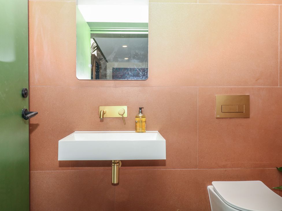 A bathroom with a sink and mirror at Reddaway Threshing Barn near Okehampton