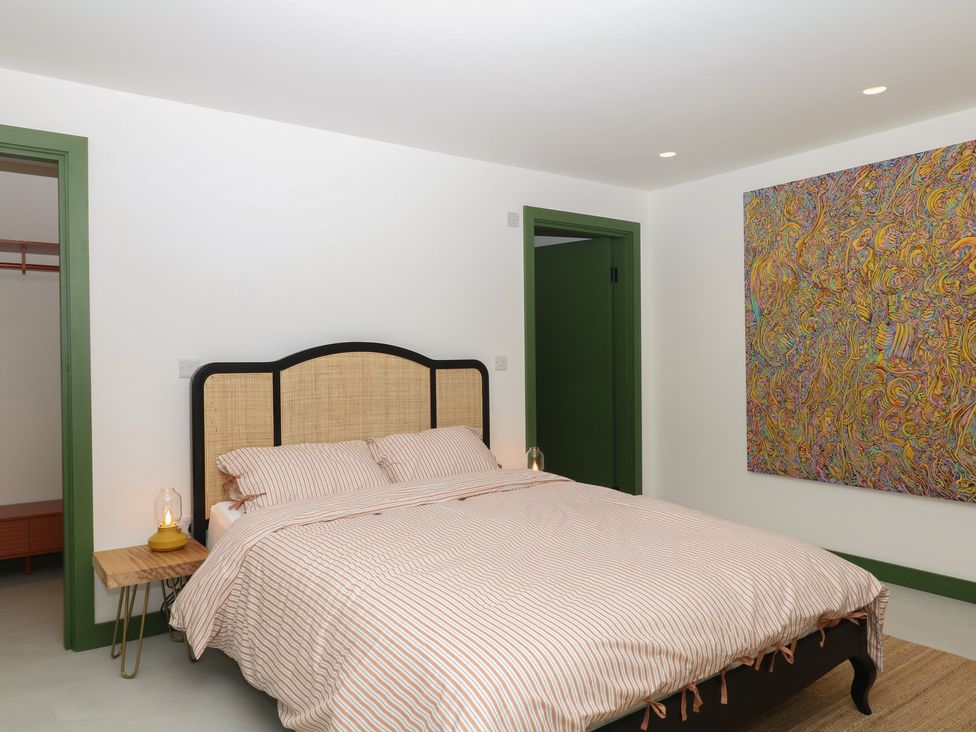A bedroom with a bed and bedside lamp at Reddaway Threshing Barn near Okehampton