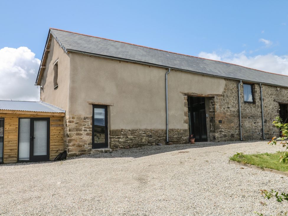 A large building with windows and door surrounded by gravel at Reddaway Threshing Barn near Okehampton