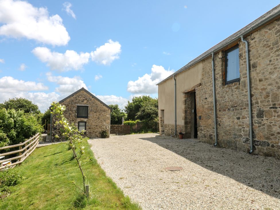 An outdoor view of a stone building and driveway at Reddaway Threshing Barn near Okehampton