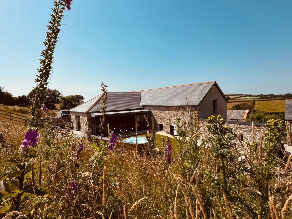 An outdoor view of a house with a pool at Reddaway Threshing Barn near Okehampton