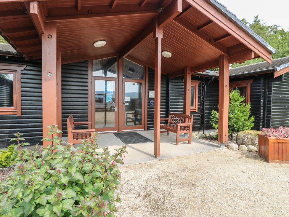An outdoor entrance with benches and planters at Shore Lodge in Brodick