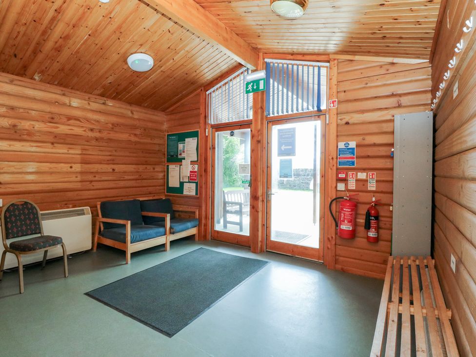 A lobby with seating and a notice board at Shore Lodge in Brodick
