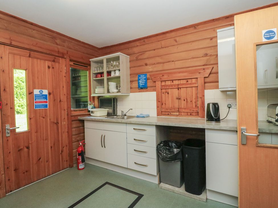 A kitchen with cupboards and a sink at Shore Lodge in Brodick