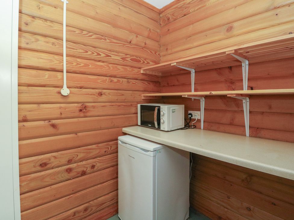 A kitchen with refrigerator and microwave at Shore Lodge Brodick