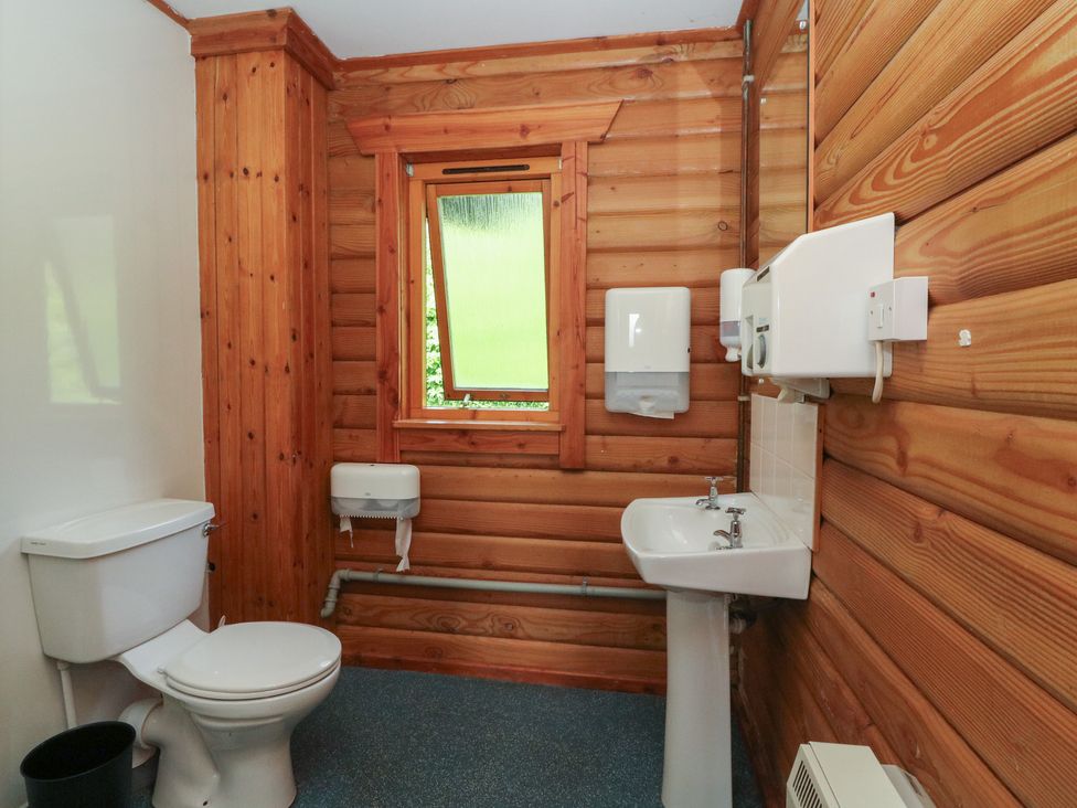 A bathroom with a toilet and sink at Shore Lodge Brodick