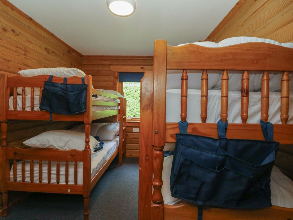 A bedroom with bunk beds and a window at Shore Lodge in Brodick