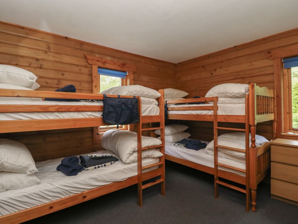 A bedroom with bunk beds and a dressing table at Shore Lodge in Brodick