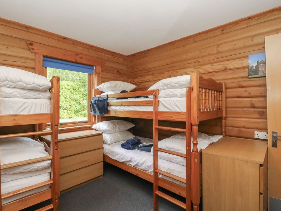 A bedroom with bunk beds and a window at Shore Lodge in Brodick