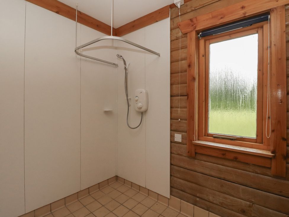 A shower area with a window at Shore Lodge in Brodick