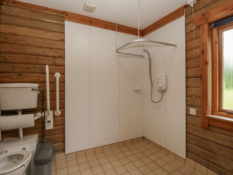 A bathroom with a shower and toilet at Shore Lodge in Brodick